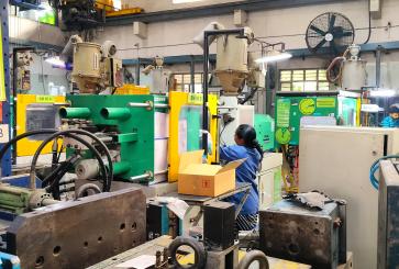 A woman works at a common facility center surrounded by machines