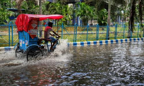 Flooded street and a rickshaw drives through it