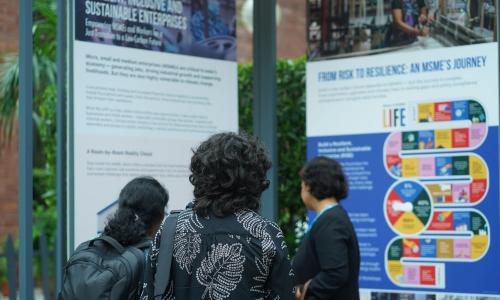 Three women look up at panels