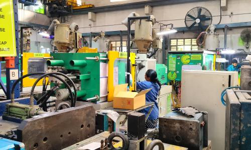 A woman works at a common facility center surrounded by machines